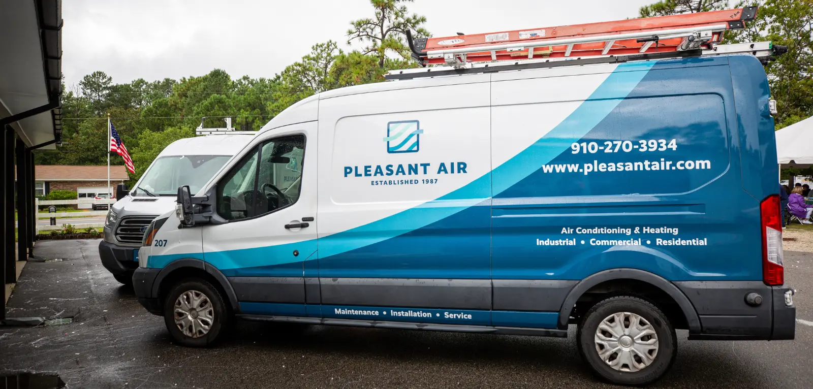 A van branded all around with blue and white graphics saying 