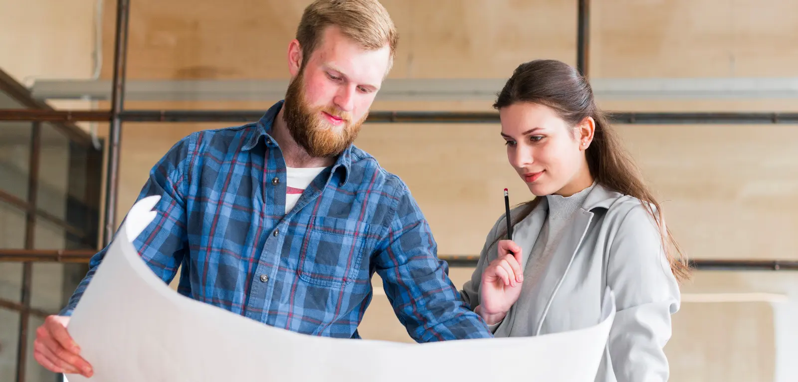 Man and woman look at large printed blueprint together
