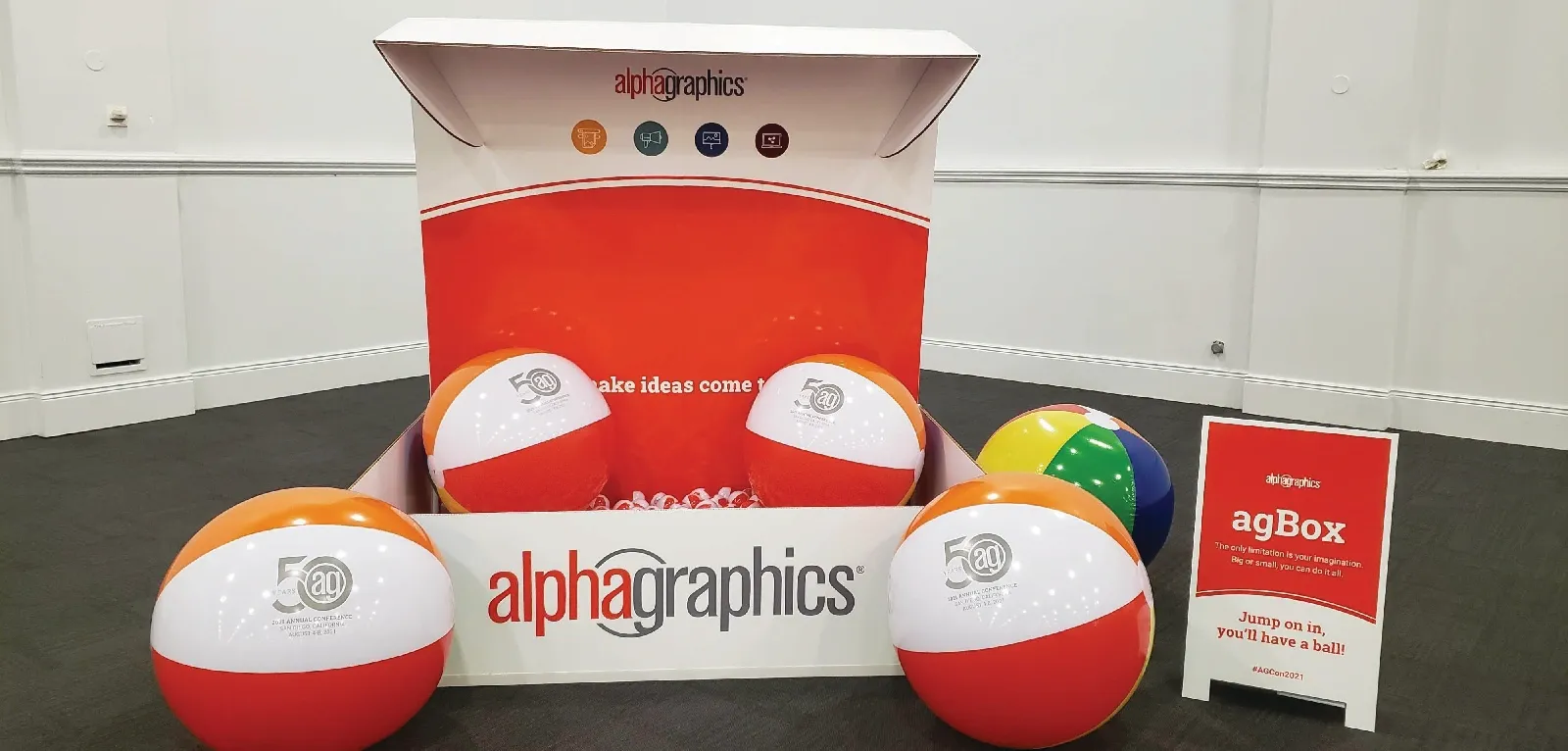 Large AlphaGraphics branded box with small and oversized balls making a ball pit inside