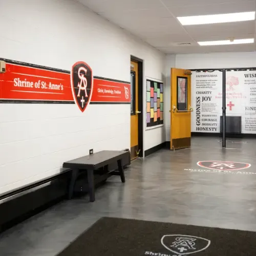 School hallway with branded rug, wall with school motto, and wall with motivational quotes