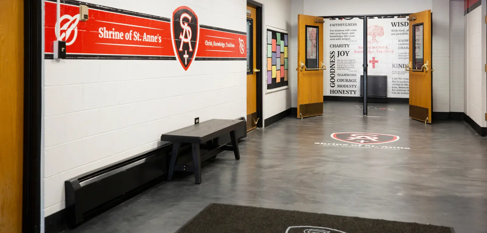 Wall painted with St. Anne's Shrine motto, rug with logo, and painted wall with motivational quotes