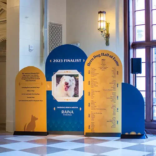 Blue and yellow signage shows a Hero Dog finalist, the Hero Dog hall-of-fame, and the categories for the awards.