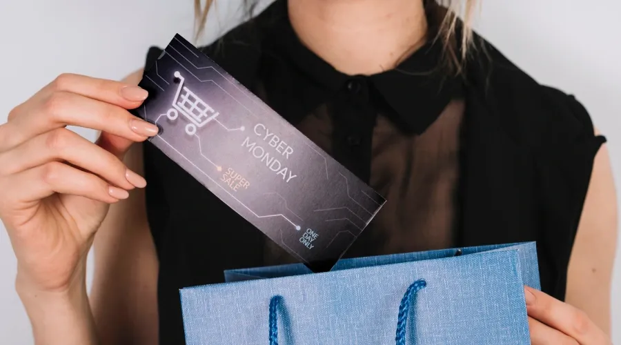Close-up of a woman holding a retail bag with printed marketing insert