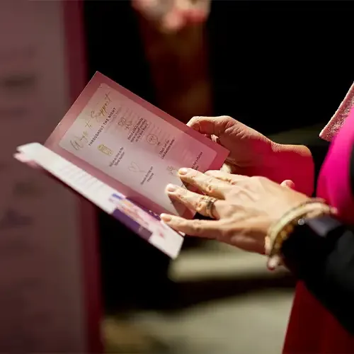A woman's hand flips through a printed material that details ways to support Madelyn's Fund.