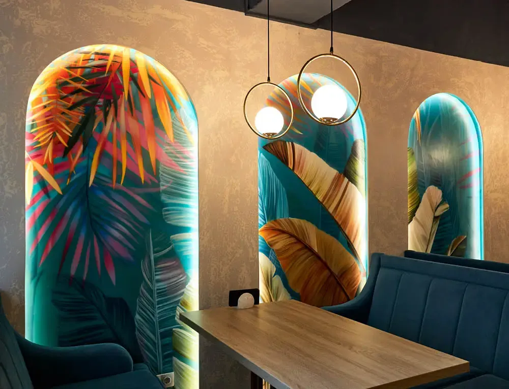 Restaurant interior has jungle graphics on the wall behind its booths